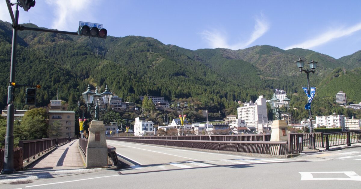 信号機と橋が調和する下呂温泉の町並みと山並みの風景