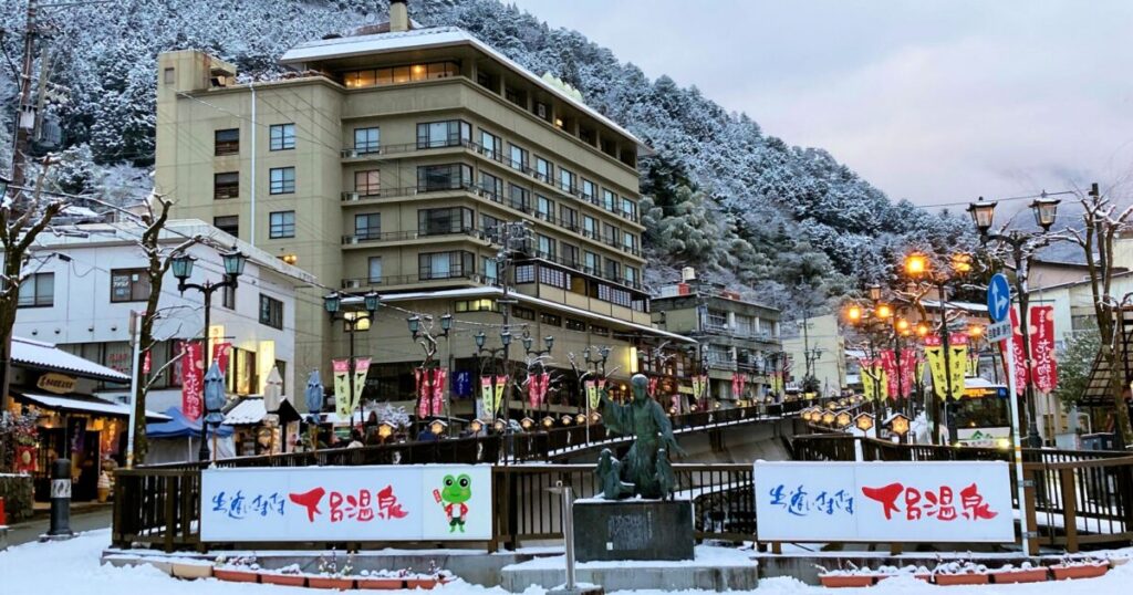 雪景色の中にたたずむ下呂温泉の温泉街と銅像