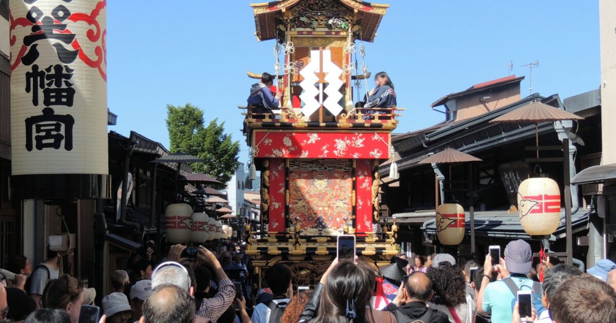 高山祭の華やかな山車と見物客で賑わう古い町並み