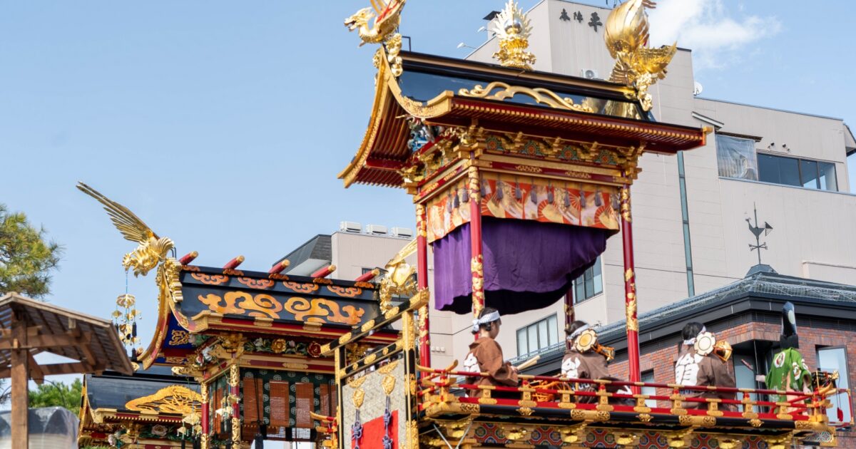 高山祭の絢爛な山車に乗る参加者たち