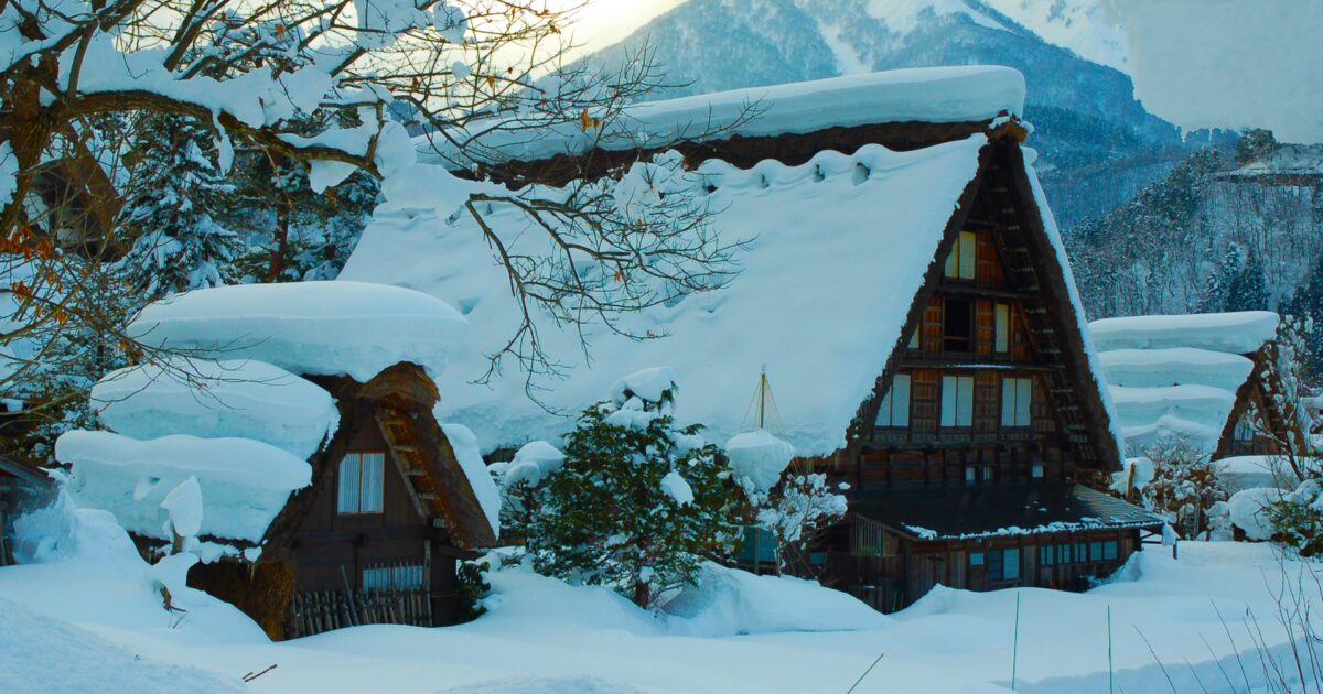 分厚い雪に覆われた白川郷の合掌造りと山々