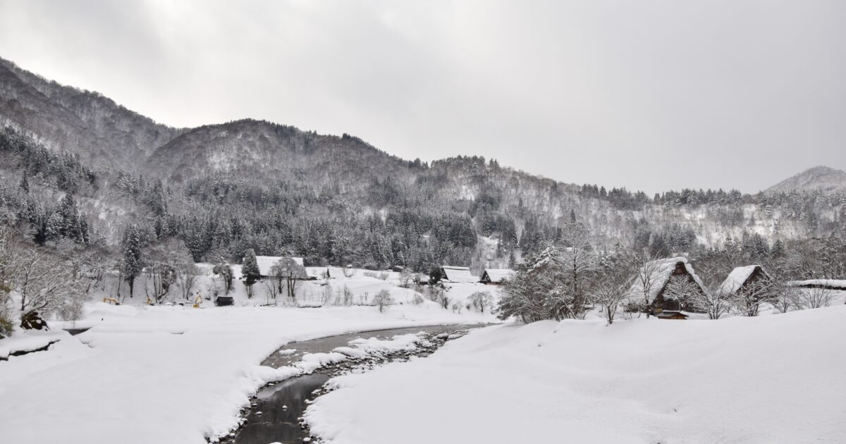 雪原と川に囲まれた白川郷の冬景色