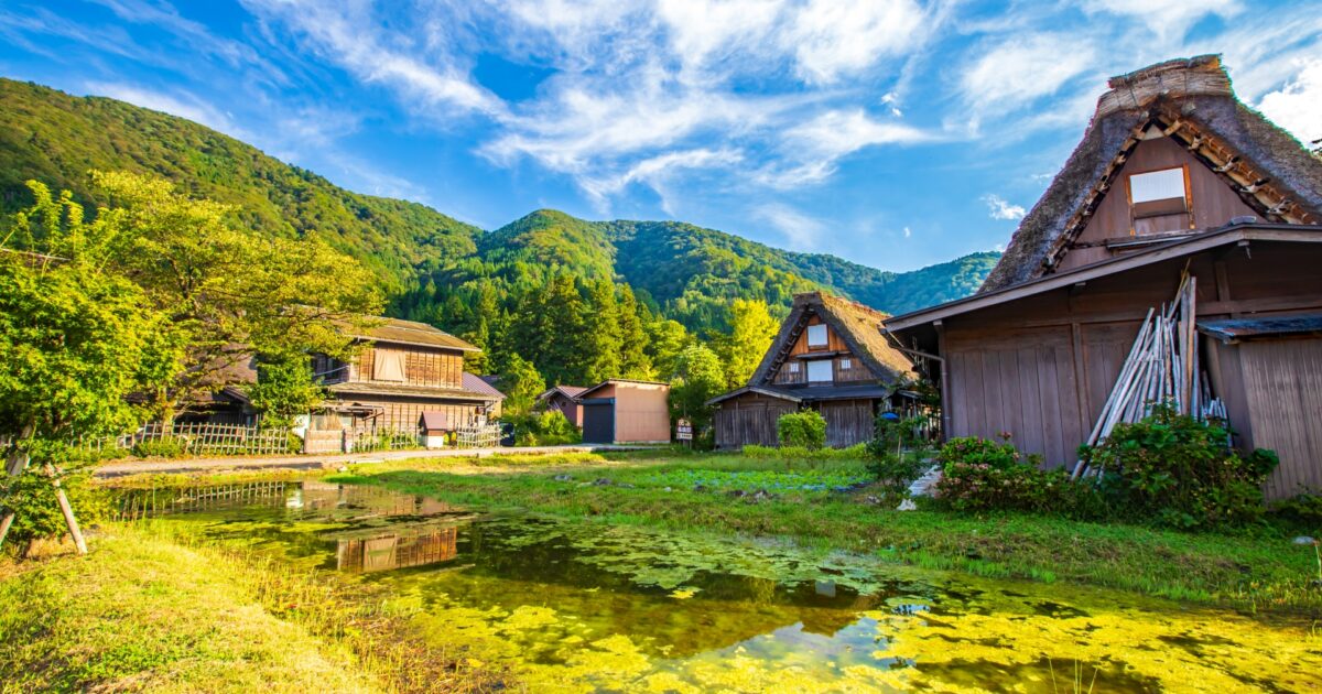 夏の青空と山に囲まれた白川郷の古民家